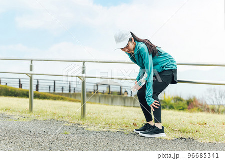 公園で運動中にふくらはぎが痛くなるアジア人女性 96685341