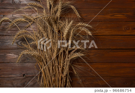 Wheat grain ear or rye spike plant on wooden table 96686754