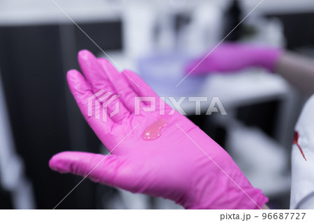 Close up of beautician hands in pink latex gloves with cosmetics for application. Beauty treatments Close up of beautician hands in pink latex gloves with cosmetics for application. Beauty treatments 96687727