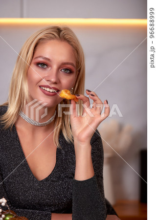 A woman with her hands eats a large appetizing shrimp. Selective focus. A woman with her hands eats a large appetizing shrimp. Selective focus. 96688999