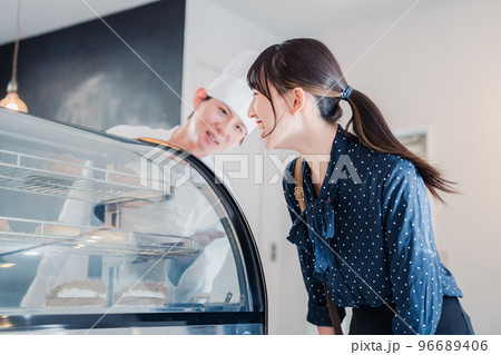 お店でスイーツを選ぶ若い女性 96689406