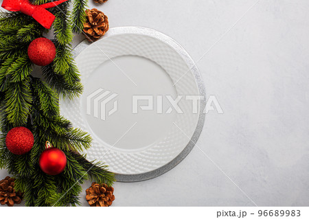 Christmas table setting consisting of a empty white plate. Top view with copy space Christmas table setting consisting of a empty white plate. Top view with copy space 96689983
