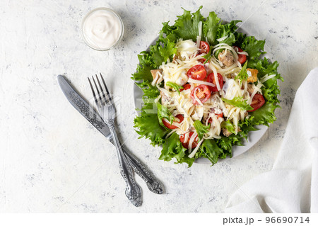Traditional caesar salad with chicken on a plate on white table with napkin fork and knife. Traditional caesar salad with chicken on a plate on white table with napkin fork and knife. 96690714