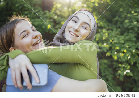 Strong female friendship. Happy two teen girls best friends holding hands and hugging Strong female friendship. Happy two teen girls best friends holding hands and hugging 96690941