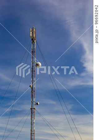 Telecommunication tower for mobile phone with antennas over a blue sky. Distribution function of contract mobile phones Telecommunication tower for mobile phone with antennas over a blue sky. Distribution function of contract mobile phones 96692042