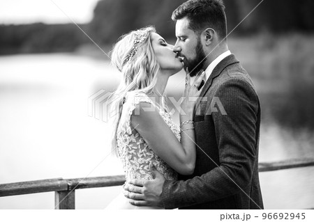 Stylish couple of happy newlyweds posing in the park on their wedding day.. Sexy kissing stylish couple. Stylish couple of happy newlyweds posing in the park on their wedding day.. Sexy kissing stylish couple. 96692945
