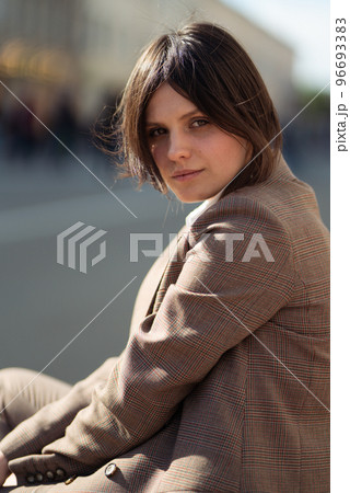 High fashion portrait of young elegant woman in brown suit walk on the street. enjoy summer lights. High fashion portrait of young elegant woman in brown suit walk on the street. enjoy summer lights. 96693383