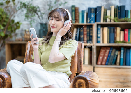 ヘッドフォンでスマホの音楽を聴く女性 96693662