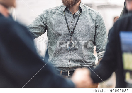 Business people shaking hands while meeting and exchanging business promotional materials and brochures on business meeting on trade-show. Business discussion talking deal concept 96695685