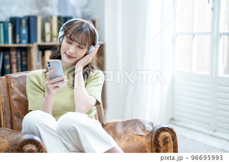 ヘッドフォンでスマホの音楽を聴く女性 ヘッドフォンでスマホの音楽を聴く女性 96695993