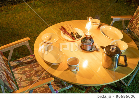 キャンプ　テーブルとランタンと食器のイメージ画像 96696606
