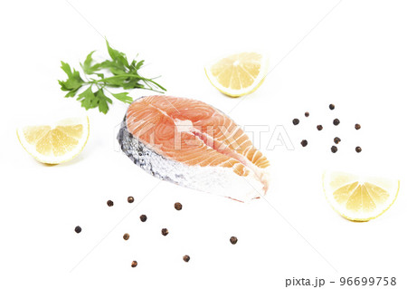 Salmon, slice of fresh raw fish with lemon slices, parsley and black pepper, isolated on white background 96699758