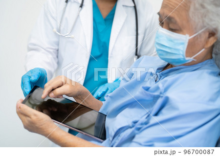 Doctor help Asian senior or elderly old lady woman patient wearing a face mask in hospital for protect safety infection and kill Covid-19 Coronavirus. Doctor help Asian senior or elderly old lady woman patient wearing a face mask in hospital for protect safety infection and kill Covid-19 Coronavirus. 96700087