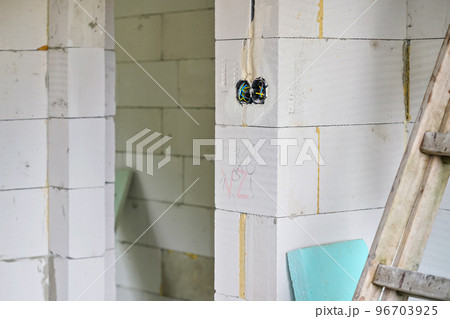 New house empty wall built from AAC - autoclaved cellular concrete, boxes with cables for electric sockets visible 96703925