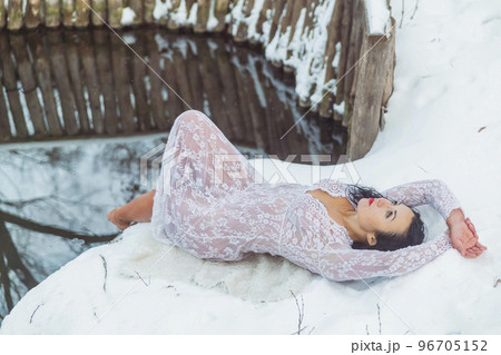 Attractive woman lying near the font in a white dress Attractive woman lying near the font in a white dress 96705152