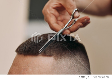 hairdresser does hairstyle with scissors in barber shop hairdresser does hairstyle with scissors in barber shop 96705870