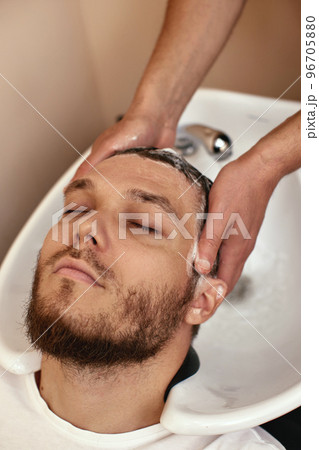Barber washing hair of caucasian man , close-up Barber washing hair of caucasian man , close-up 96705880