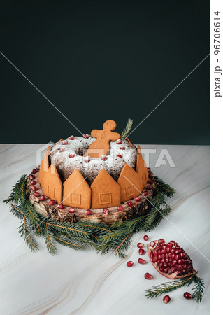 Christmas cake with funny gingerbread men on marble table with black background for your copy. Christmas pomegranat cake with festive decoration 96706614