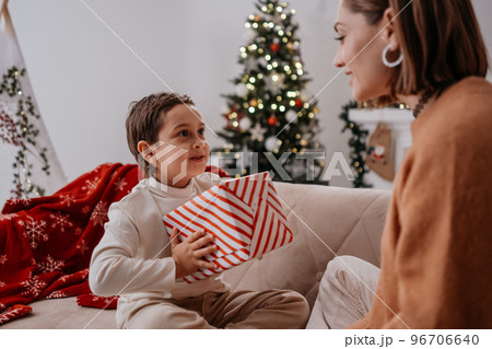 Carrying woman giving Christmas present to the boy 96706640