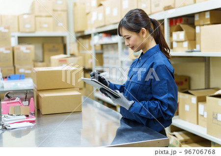倉庫で在庫管理をする女性作業員 96706768