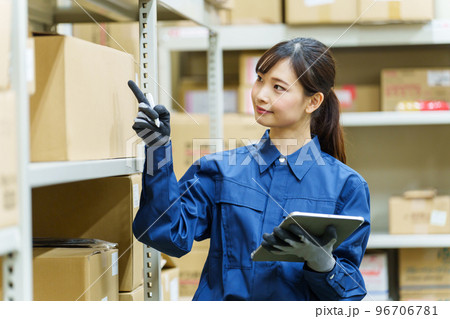 倉庫で在庫管理をする女性作業員 96706781