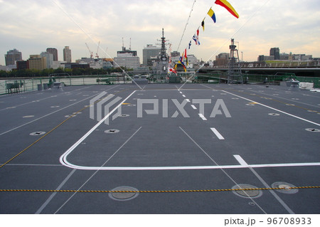 輸送艦「おおすみ」の上甲板前方と、横浜市街のビル群 96708933