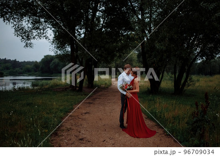 An elegant man in a shirt hugs a slender girl. 96709034