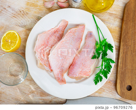 Unprepared chicken fillets on kitchen table Unprepared chicken fillets on kitchen table 96709276
