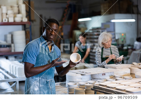 Portrait of positive man potter in workshop Portrait of positive man potter in workshop 96709509