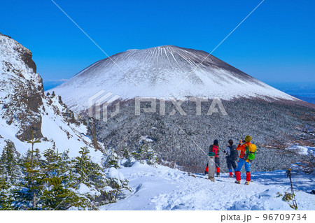 冬の長野県小諸市の黒斑山付近の槍ヶ鞘から浅間山を眺める女性登山者 96709734
