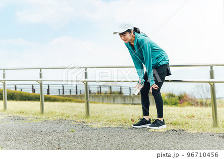 ランニング・ウォーキング中に息切れ・疲労・めまいで困るスポーツウェアのアジア人女性 ランニング・ウォーキング中に息切れ・疲労・めまいで困るスポーツウェアのアジア人女性 96710456