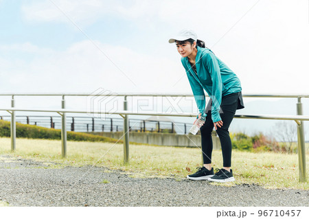 風邪をひいて体調不良で倦怠感を感じながら有酸素運動するランナーのアジア人女性 風邪をひいて体調不良で倦怠感を感じながら有酸素運動するランナーのアジア人女性 96710457
