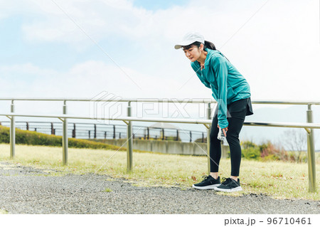 運動中に呼吸困難・喘息・息切れで苦しくて困るスポーツウェアのアジア人女性 96710461