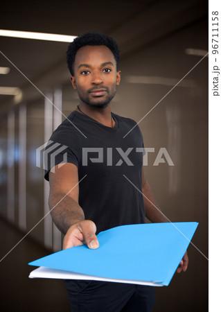 office worker giving folder document to colleague holding paperwork working on file 96711158