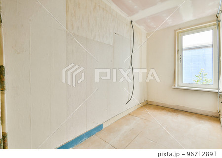 Empty room with windows and radiator in daylight 96712891