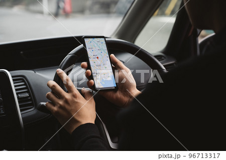 スマホを見ながら車を運転する男性男性イメージ スマホを見ながら車を運転する男性男性イメージ 96713317