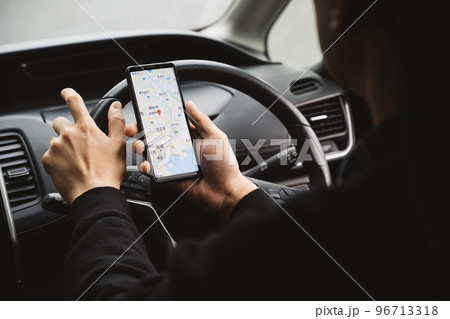 スマホを見ながら車を運転する男性男性イメージ スマホを見ながら車を運転する男性男性イメージ 96713318