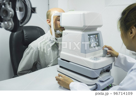 Man examining eyesight in optical clinic. Man examining eyesight in optical clinic. 96714109