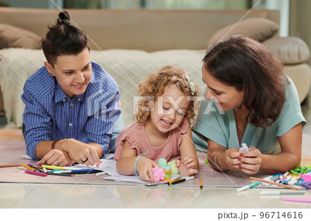 Happy mothers and little daughter playing with toys and drawing pictures together at home 96714616