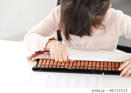 そろばん教室でそろばんの珠をはじいている生徒。幼児または小学生の女の子。 そろばん教室でそろばんの珠をはじいている生徒。幼児または小学生の女の子。 96715525