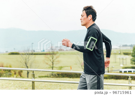 ランニング・トレーニング中にスマホでフィットネスアプリを使うスポーツウェアのアジア人男性 ランニング・トレーニング中にスマホでフィットネスアプリを使うスポーツウェアのアジア人男性 96715961