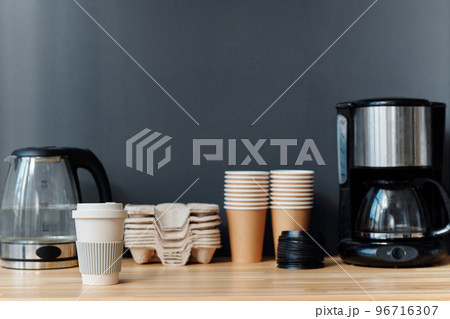 Close-up of coffee maker and teapot with eco cups preparing for making coffee during coffee break at office 96716307