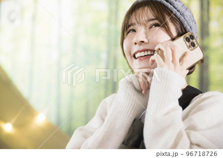 おうちキャンプ中にスマホで通話をする若い女性　　家キャン おうちキャンプ　キャンプイメージ 96718726