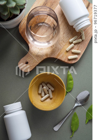 White pill bottles on green background. Health care food supplements, vitamins and medicaments White pill bottles on green background. Health care food supplements, vitamins and medicaments 96719377