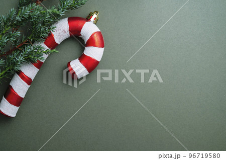 Christmas green background. Fir tree branches, seasonal ornament candy canes. Creative flat lay, top view copy space Christmas green background. Fir tree branches, seasonal ornament candy canes. Creative flat lay, top view copy space 96719580
