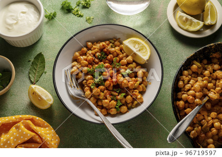 Cooked Chickpea dish with curry and spices, homemade vegan chickpeas, healthy food, colorful green background Cooked Chickpea dish with curry and spices, homemade vegan chickpeas, healthy food, colorful green background 96719597
