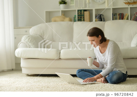 Portrait of a beautiful woman with a laptop on the floor 96720842