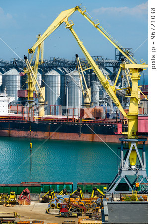 industrial seaport infrastructure, sea, cranes and dry cargo ship, grain silo, bulk carrier vessel and grain storage elevators, concept of sea cargo transportation industrial seaport infrastructure, sea, cranes and dry cargo ship, grain silo, bulk carrier vessel and grain storage elevators, concept of sea cargo transportation 96721038