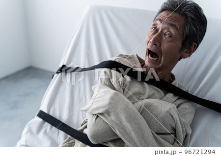 ベッドに縛り付けられた男性 96721294
