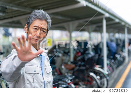 駐輪場で制止する管理者のシニア男性 96721359